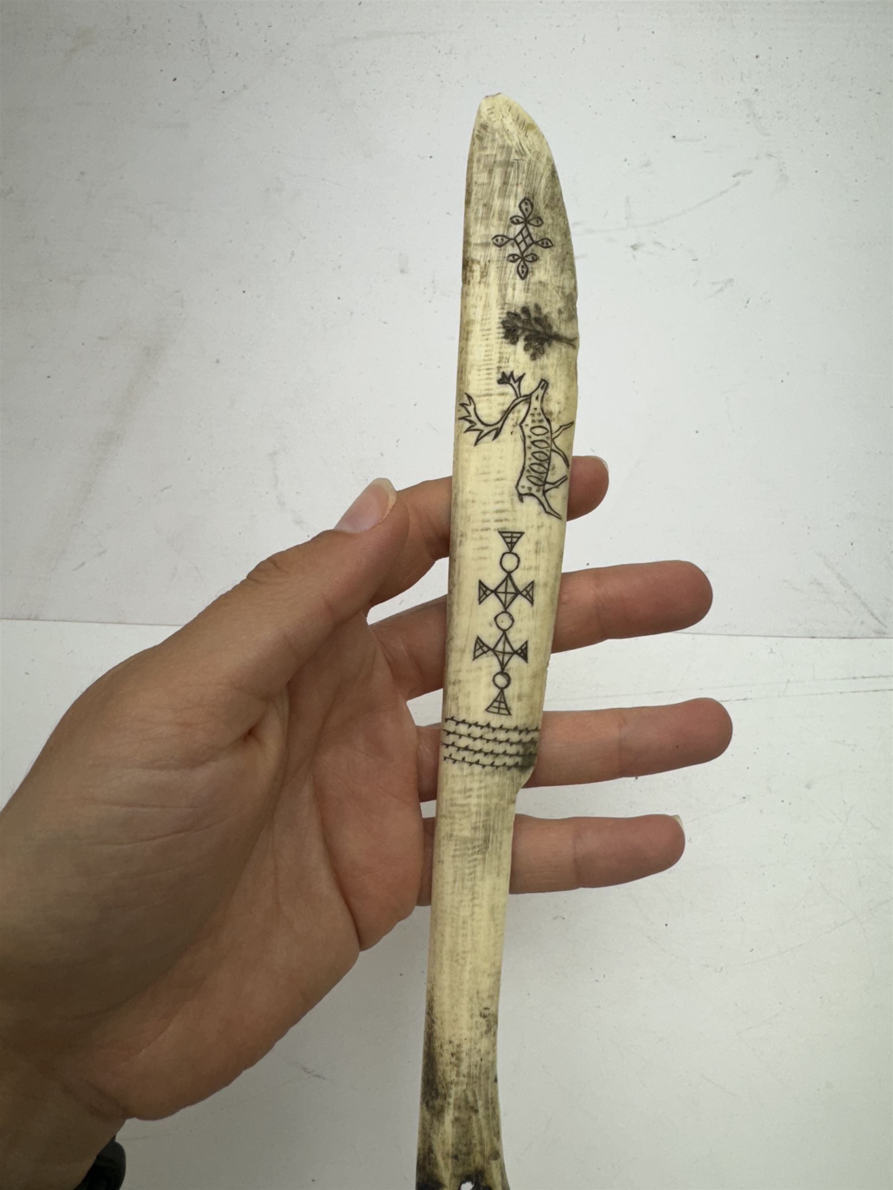 Inuit scrimshaw carved bone scraping knife, decorated with deer and tree, L25cm