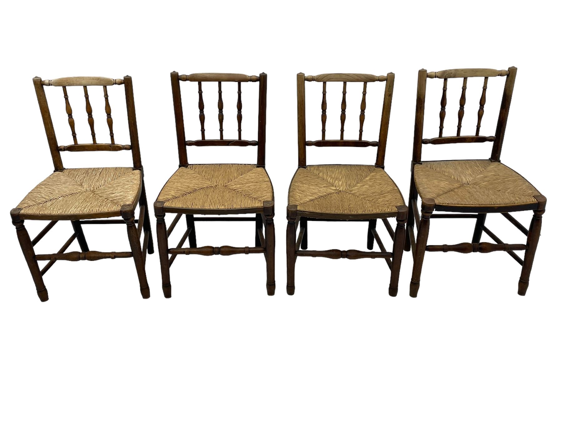 Set of four 19th century elm spindle back chairs, bar cresting rail over three turned vertical spindles, rush seat on turned supports united by turned stretchers 