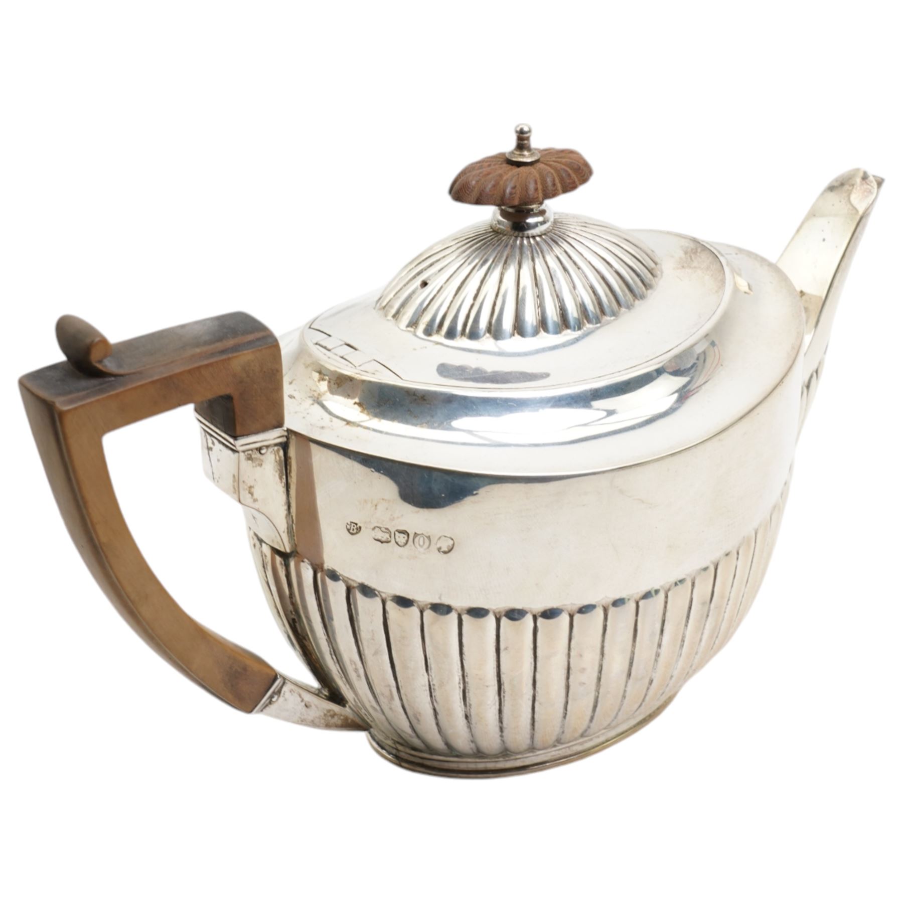 Victorian silver teapot of oval design with half body decoration, stained wood handle and lift London 1889 Maker Walter & John Barnard 