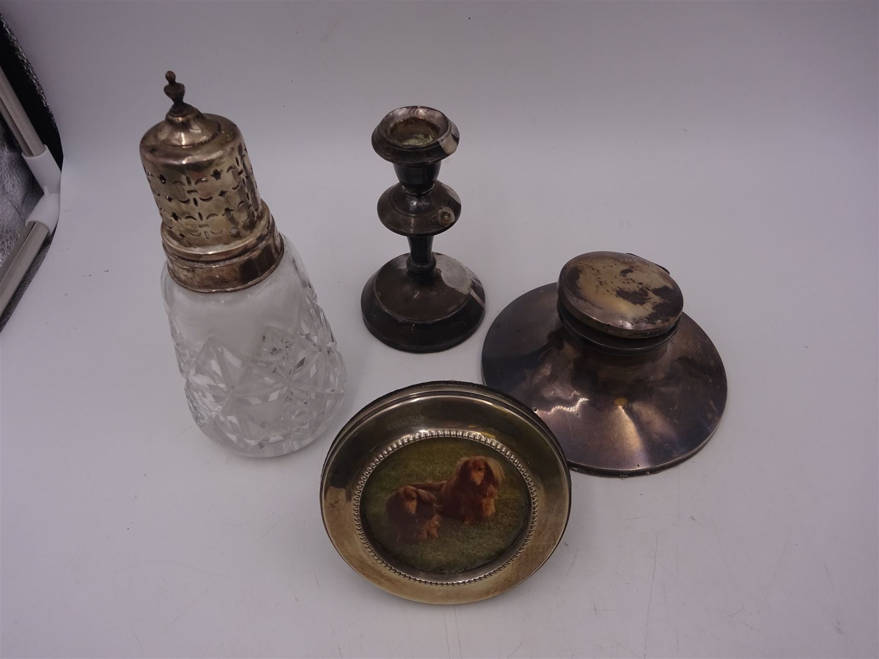 Group of silver mounted items, including cut glass sugar caster, capstan inkwell, circular photograph frame and dwarf candlestick, candlestick H11cm