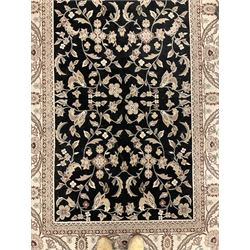 Persian design dark indigo ground rug, the field decorated with trailing branches and foliate motifs, repeating scrolling border with stylised plant motifs