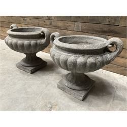 Pair of Victorian design cast stone squat garden urns with handles, pedestal base on square plinth