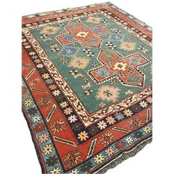 Caucasian turquoise ground rug, two medallions on a field decorated with stylised animal and geometric motifs, the guarded border decorated with further geometric motifs