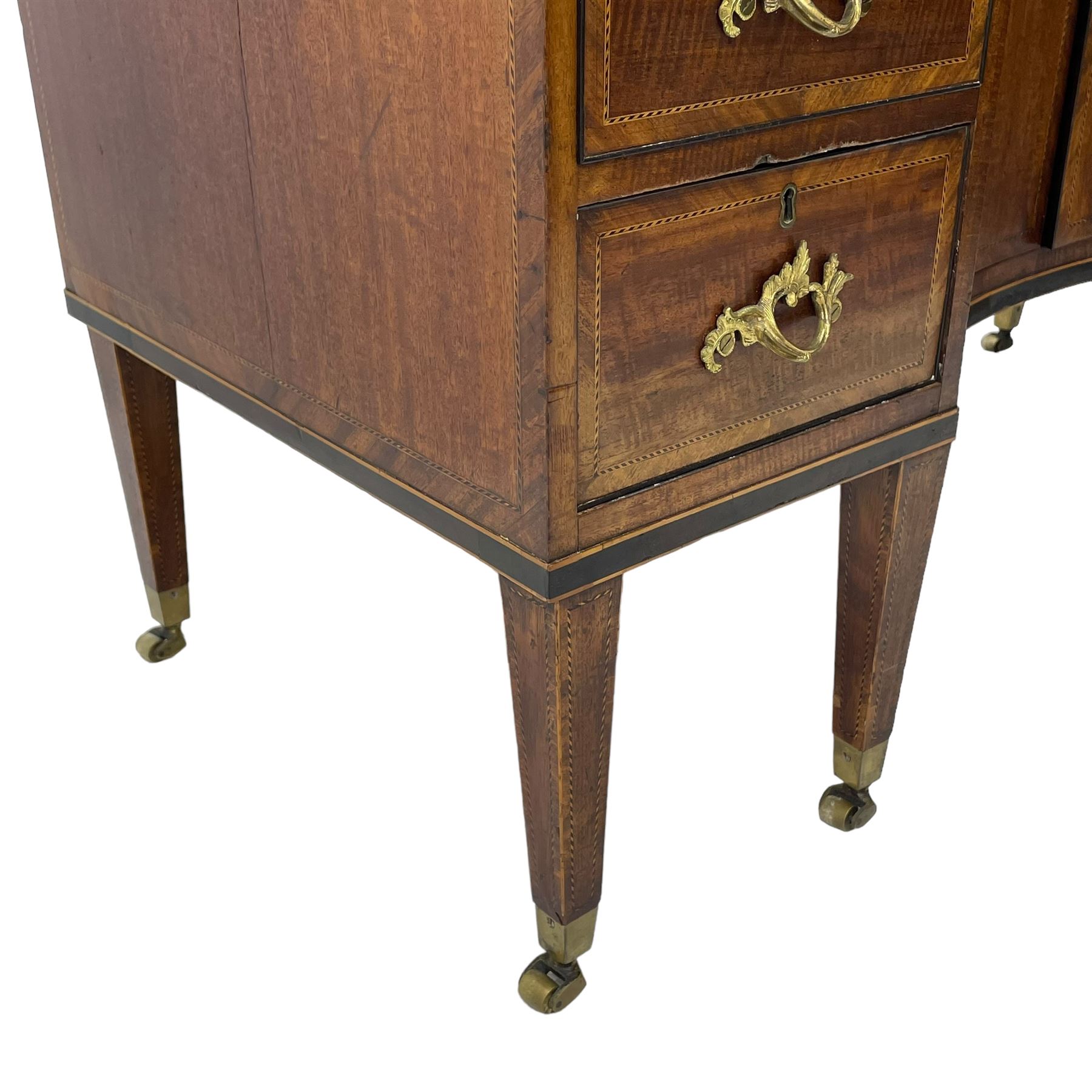 Late 19th century mahogany and satinwood dressing chest, the raised middle section hinges to reveal an interior fitted with lidded compartments, removable tray, single drawer and glass scent bottles, lift-up bevelled mirror with adjustable hinged mechanism, fitted with a further eight cock-beaded graduating drawers and curved kneehole with double cupboard, square tapering supports on brass cups and castors, inlaid throughout with checkered stringing, ornate Rococo cast gilt metal handles