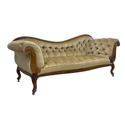 19th century walnut framed chaise longue, shaped back over scrolled arms decorated with moulded curling acanthus carvings, upholstered in deep buttoned champagne fabric, raised on cabriole supports with applied floral carved decoration, on castors