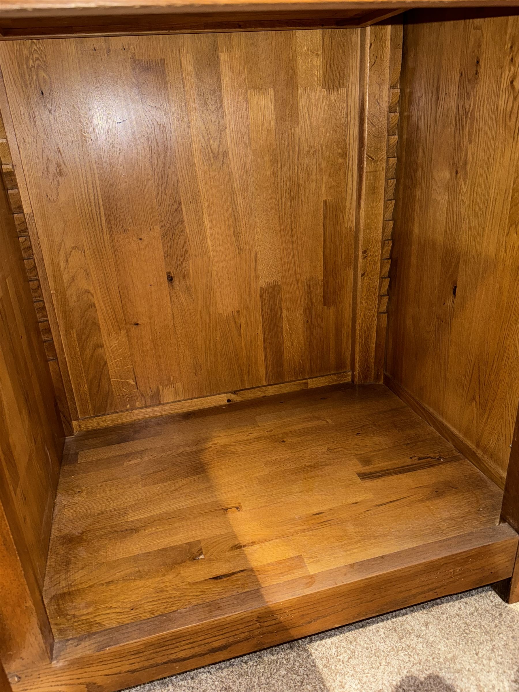 Large 20th century oak dresser, projecting cornice over open arched central section with two shelves, flanked by two panelled cupboards with two shelves, lower section with three drawers above three cupboards, on stile supports 