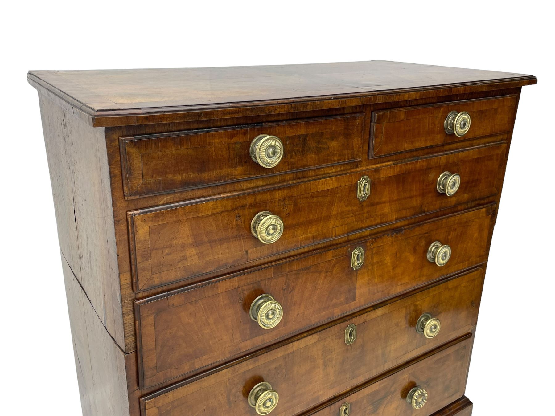 George I walnut chest, moulded rectangular top with book-matched veneers within crossbanding, fitted with two short over four long graduating drawers, moulded drawer fronts with brass handles, on bracket feet, the chest will split into two sections 