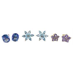 Two pairs of 9ct gold flower head stud earrings including tanzanite and topaz and a pair of 10ct white gold oval mystic blue topaz stud earrings, stamped