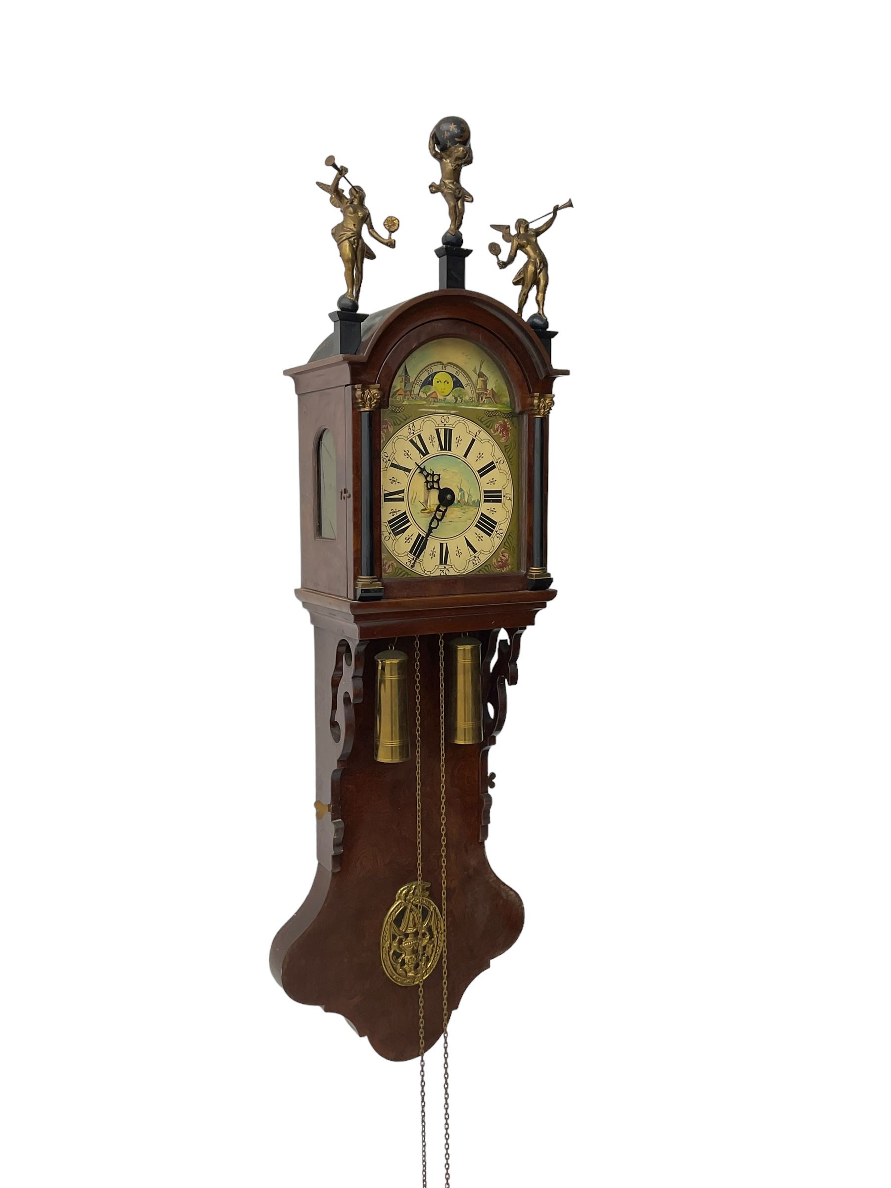 20th century weight driven Dutch WUBA wall clock -  with a break arch top and mounted gilt figures to the arch, painted dial with working moon disc, chapter ring with Roman numerals and pierced steel hands, twin train chain driven movement striking the hours on a bell. With pendulum and brass cased weights.