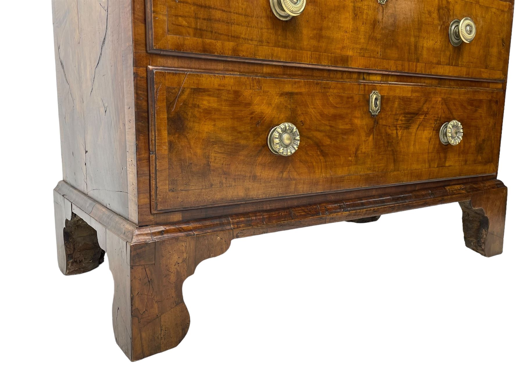 George I walnut chest, moulded rectangular top with book-matched veneers within crossbanding, fitted with two short over four long graduating drawers, moulded drawer fronts with brass handles, on bracket feet, the chest will split into two sections 