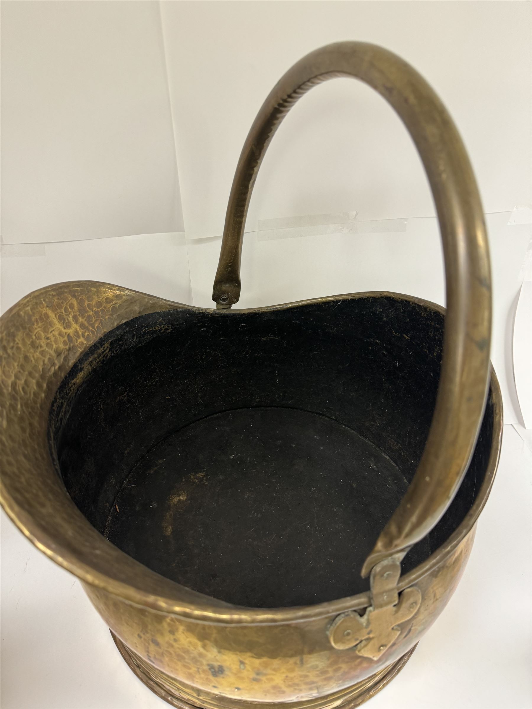 Middle eastern copper bucket, with chased and embossed band of animal decoration, together with a copper jardinière embossed with floral panels, copper plate with embossed leaf motif and two brass helmet shaped coal scuttles, bucket H26cm