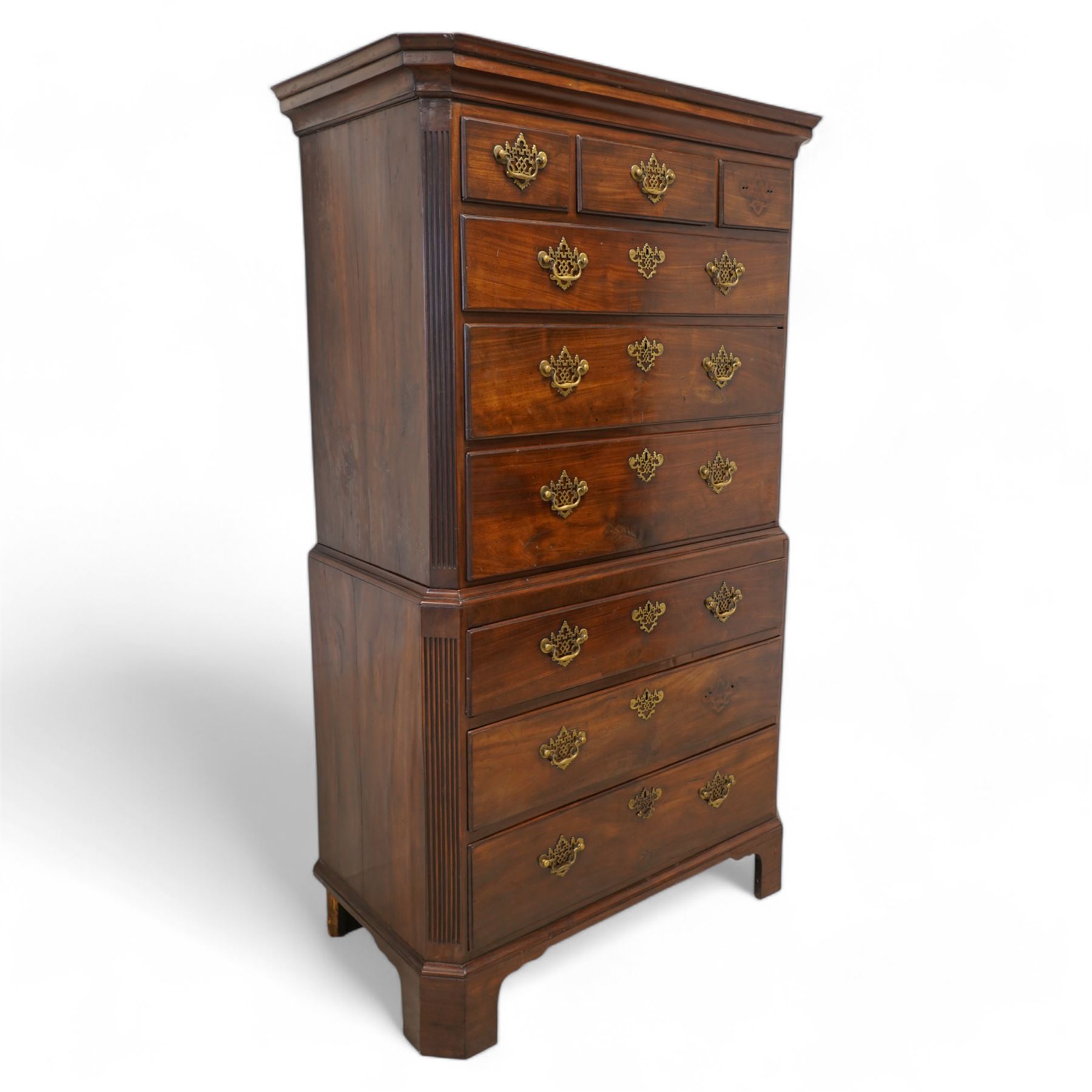 George III mahogany canted chest-on-chest, moulded cornice over three short and six long moulded drawers, shaped and pierced handle plates with swan neck handles, fluted upright canted corners, on bracket feet 