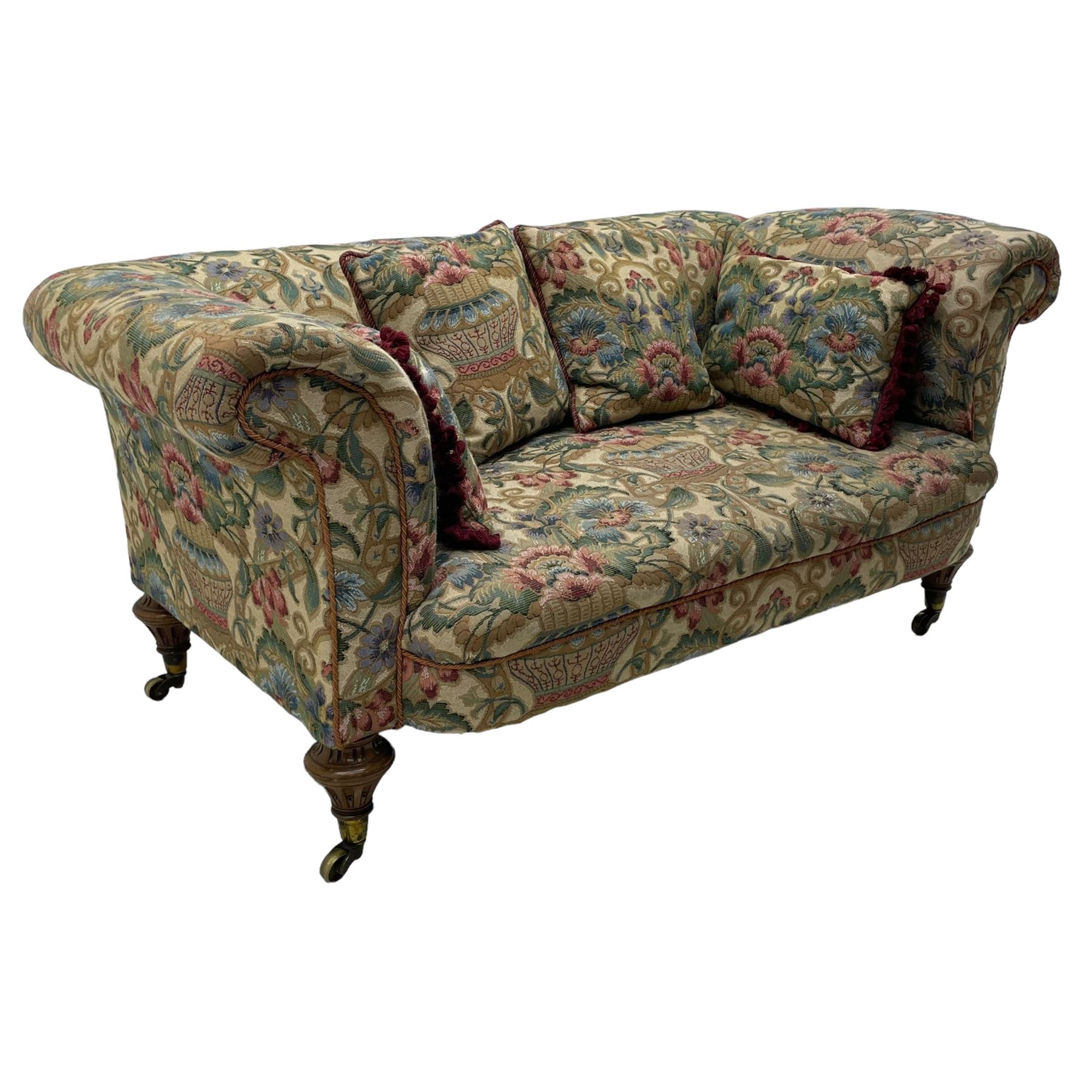 Mid-19th century walnut framed two-seat sofa, rolled arms over sprung seat, single drop-end action, raised on turned and fluted feet with brass cups and castors, upholstered by E & S Gott in traditional floral pattern fabric decorated with urns