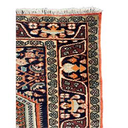 North West Persian Bidjar rug, orange peach ground extended field on indigo ground, decorated with floral Herati motifs, repeating waved border decorated with stylised plant motifs