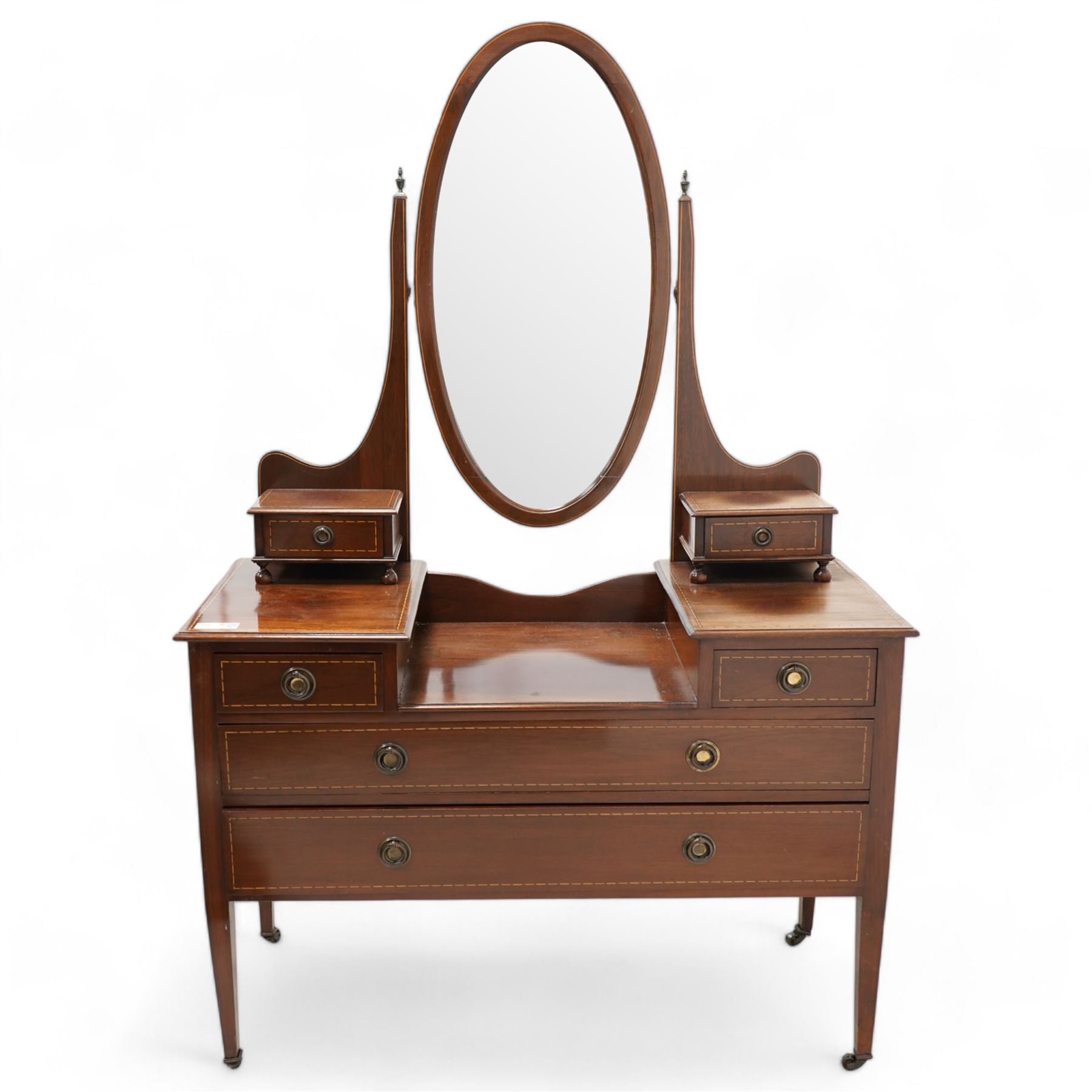 Edwardian inlaid mahogany drop-centre dressing table, bevelled oval swing mirror over trinket drawers, fitted with two short and two long drawers, on square tapering supports with brass castors