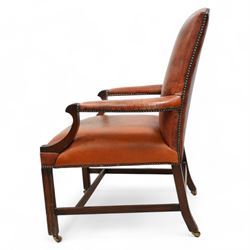 Georgian design Gainsborough elbow chair, upholstered in leather with studwork bands, moulded square supports united by H-stretcher, on brass castors 