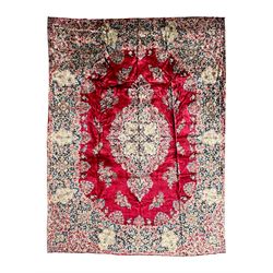 Persian Kirman carpet, the bold ruby field hosting a multi-lobed central medallion, embell...