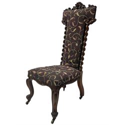 Victorian walnut prie-dieu chair, cresting rail carved with cartouche and extending scrolling foliage, back flanked by spiral turned column uprights, upholstered in foliate patterned fabric, raised on cabriole supports with scroll feet and castors