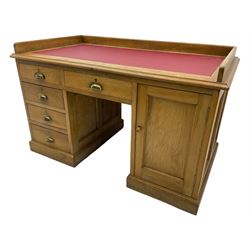 20th century oak desk, moulded rectangular top with raised back and inset leather writing surface, fitted with five drawers and single panelled cupboard, on moulded plinth base