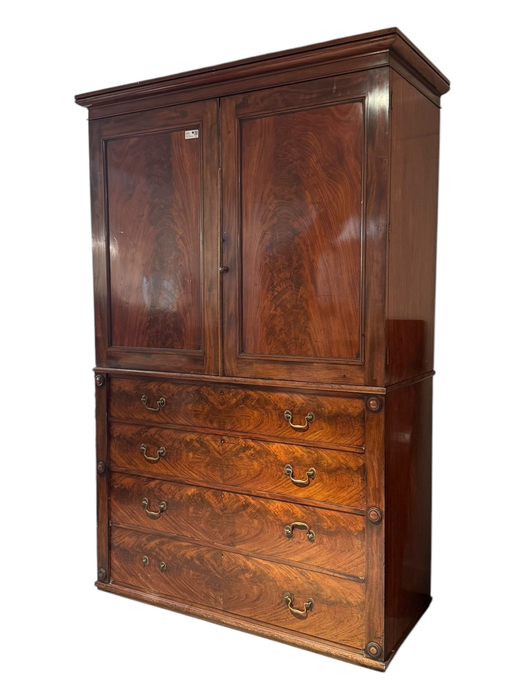 Victorian mahogany linen-press, moulded cornice over two figured panelled doors, the interior fitted with five slides and hanging rail, four long drawers below 