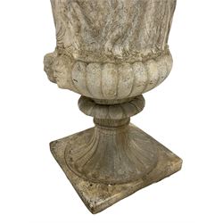 Cast stone Campana shaped urn, decorated with festival scenes over gadrooned underbelly, circular foot on square base