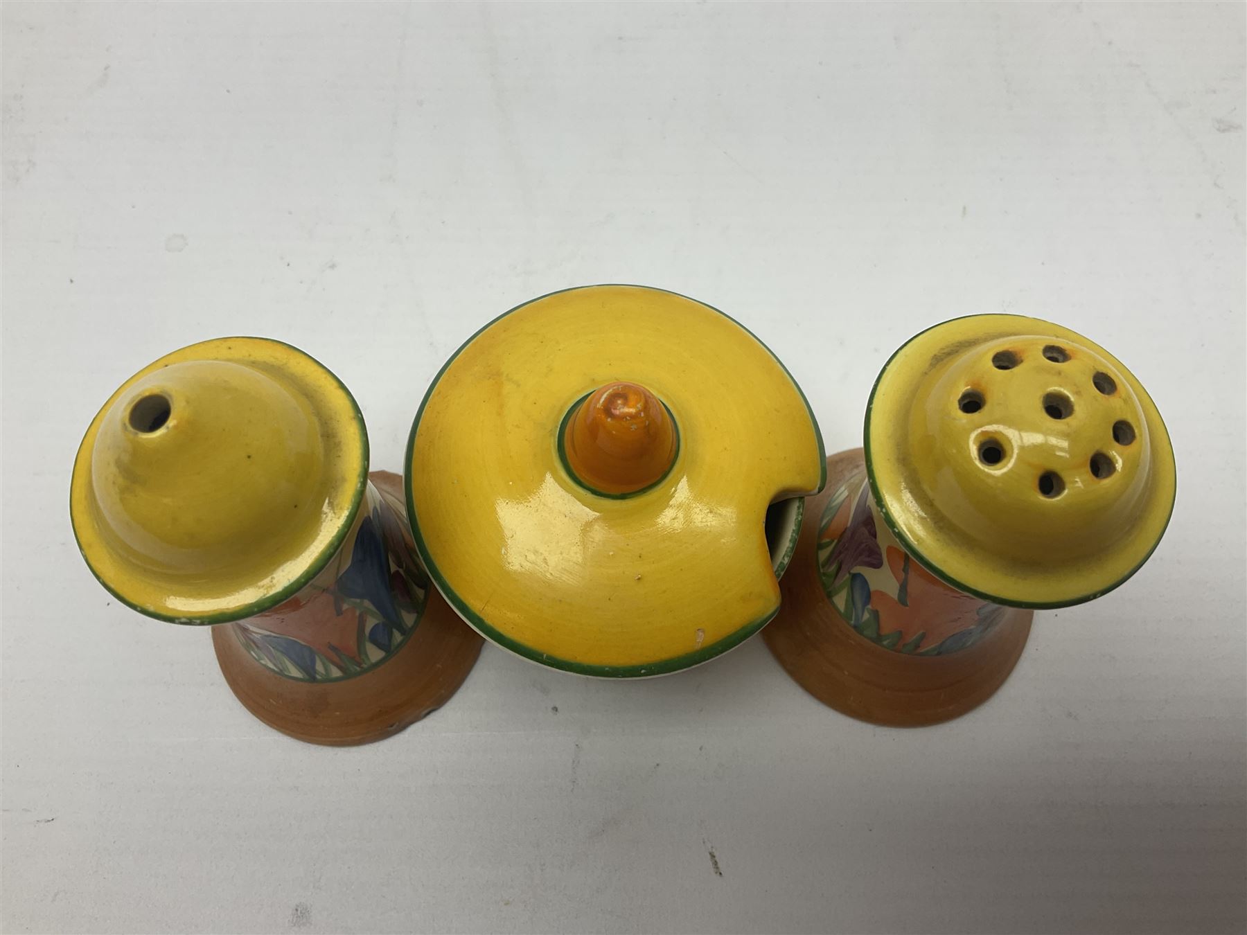 Clarice Cliff Bizarre for Newport Pottery, Muffineer cruet set in Crocus pattern, comprising mustard pot, salt shaker and pepper shaker, with printed marks beneath  