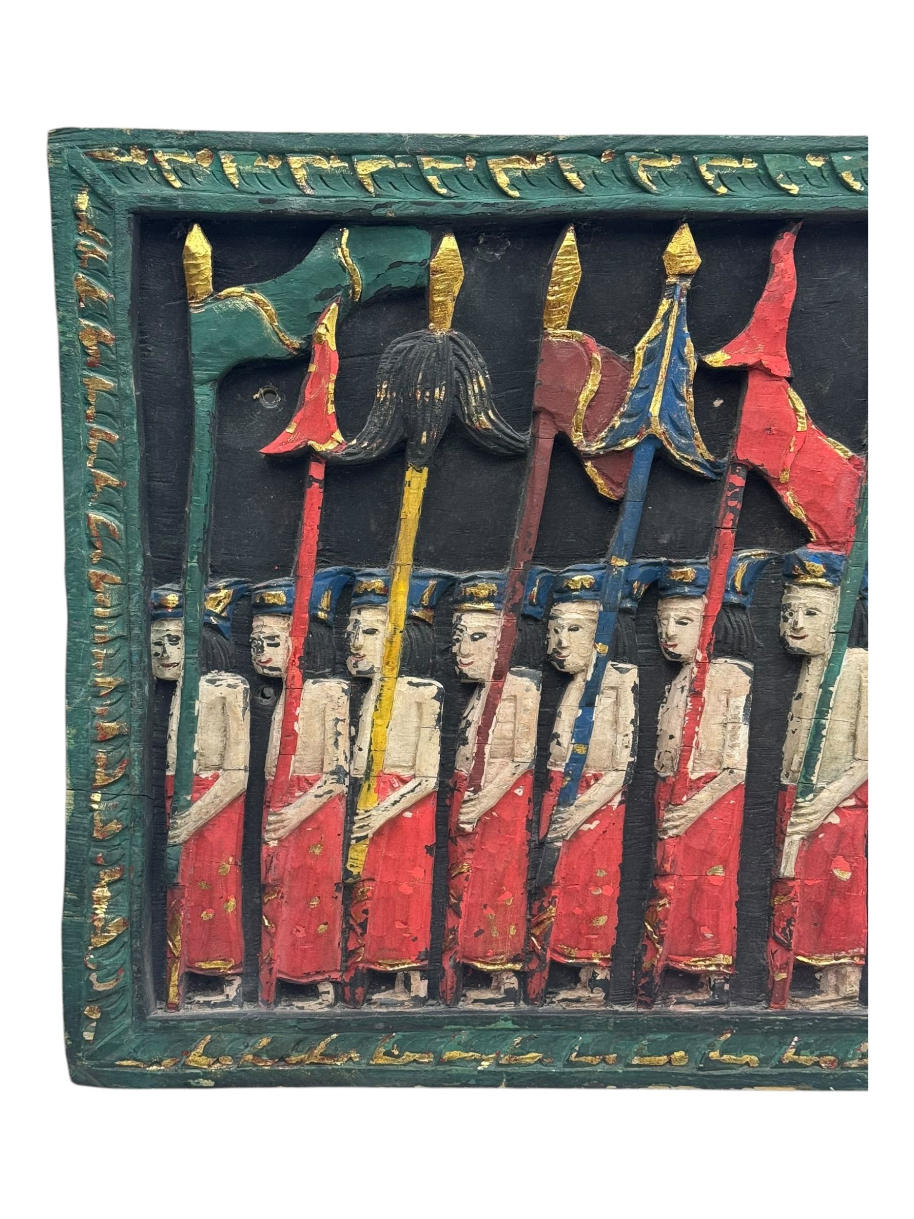 Rectangular relief carved and painted wall hanging panel, depicting ceremonial procession with soldiers and flag bearers on horses and elephants