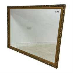 Large rectangular gilt framed wall mirror, decorated with trailing leafy branches and flowerheads, bevelled glass plate 