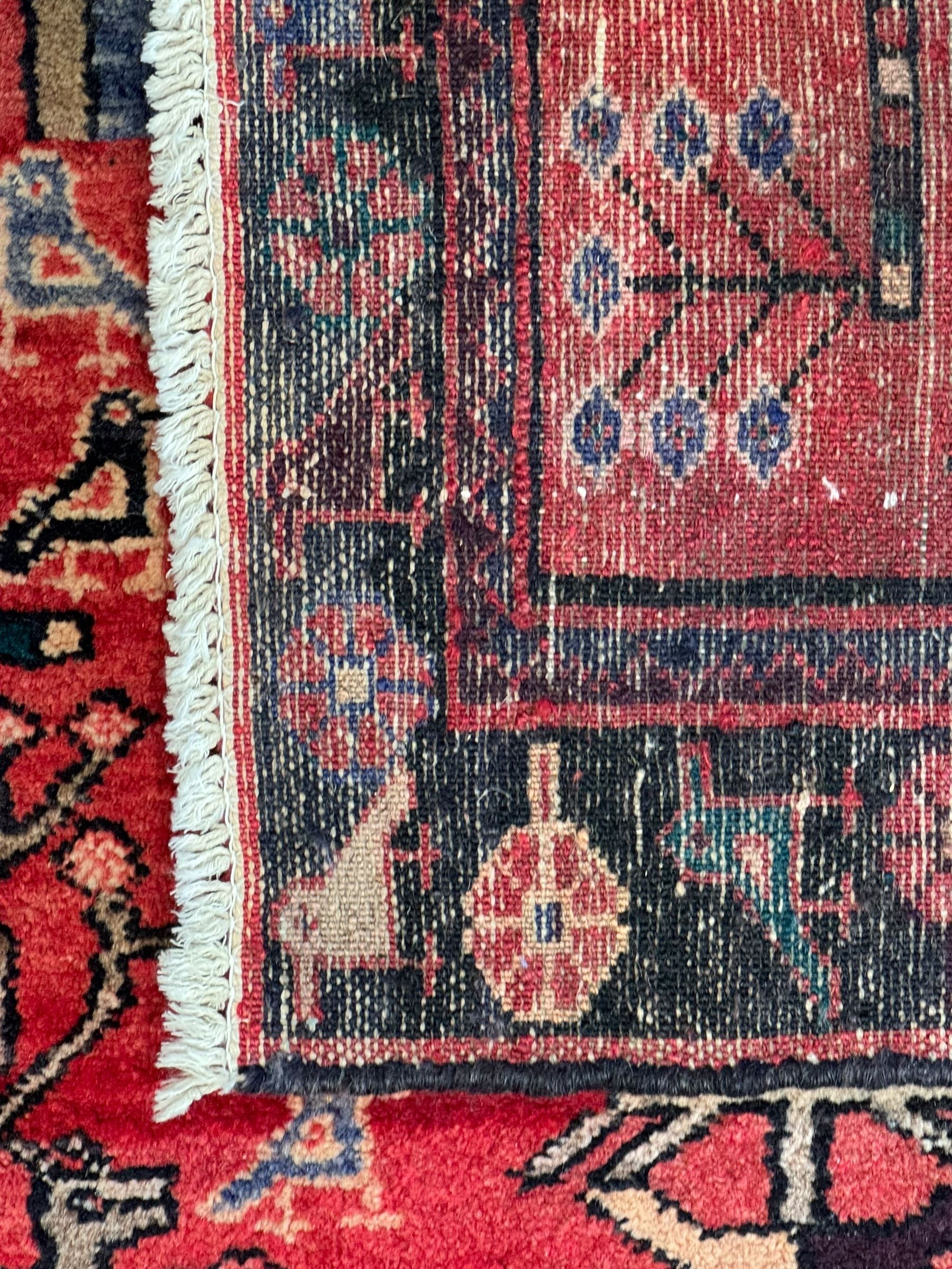 Persian crimson ground runner, the field decorated with stylised tree and animal motifs, indigo ground border decorated with alternating stylised flowerhead and bird motifs 