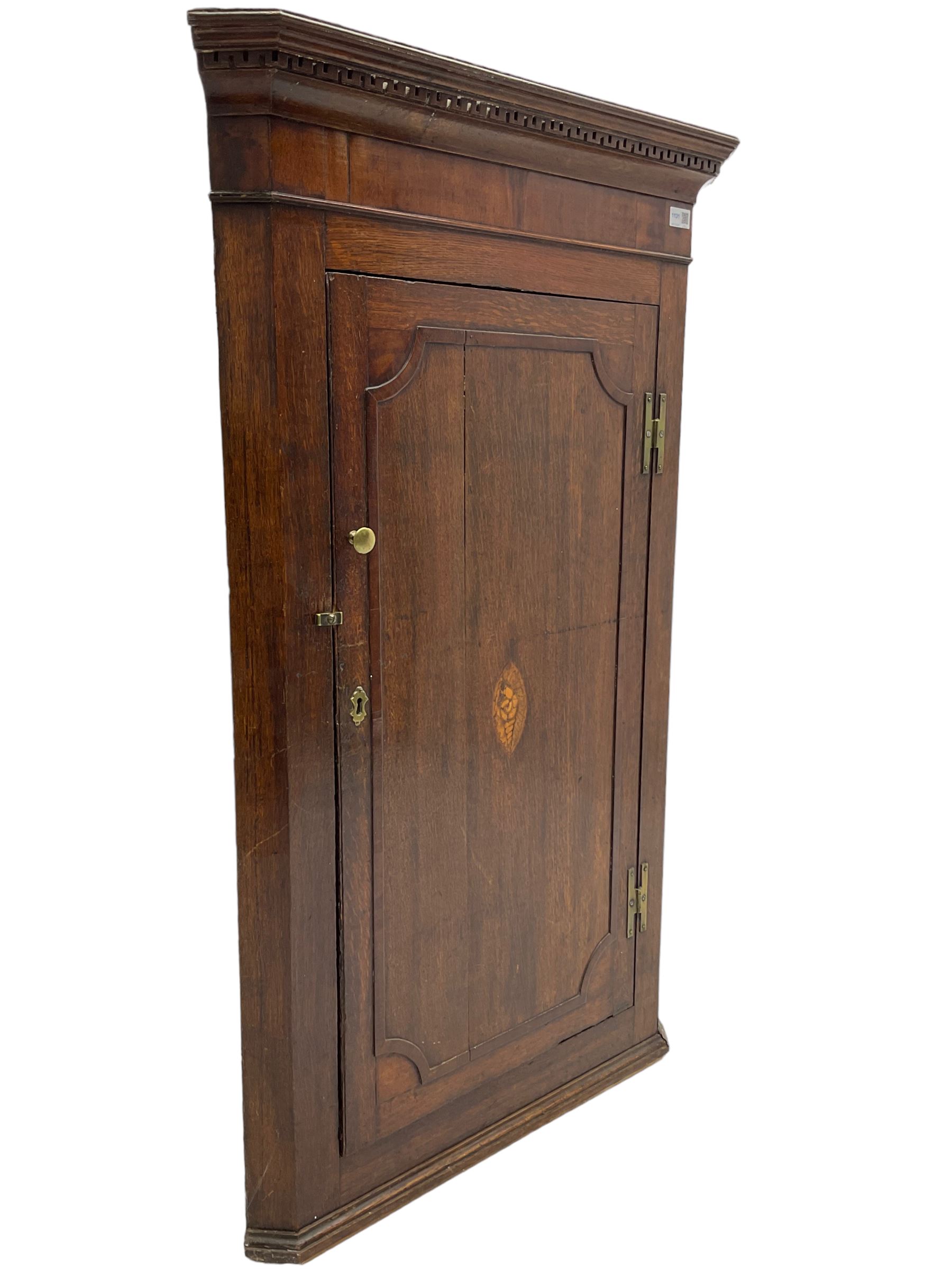 George III oak and mahogany wall hanging corner cupboard, single door decorated with central inlaid shell motif enclosing three shelves