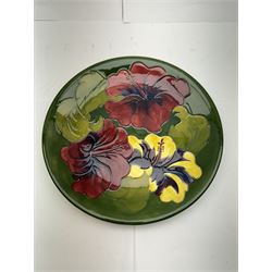 Moorcroft plate, in Hibiscus pattern on a green ground, with makers mark beneath D26cm  