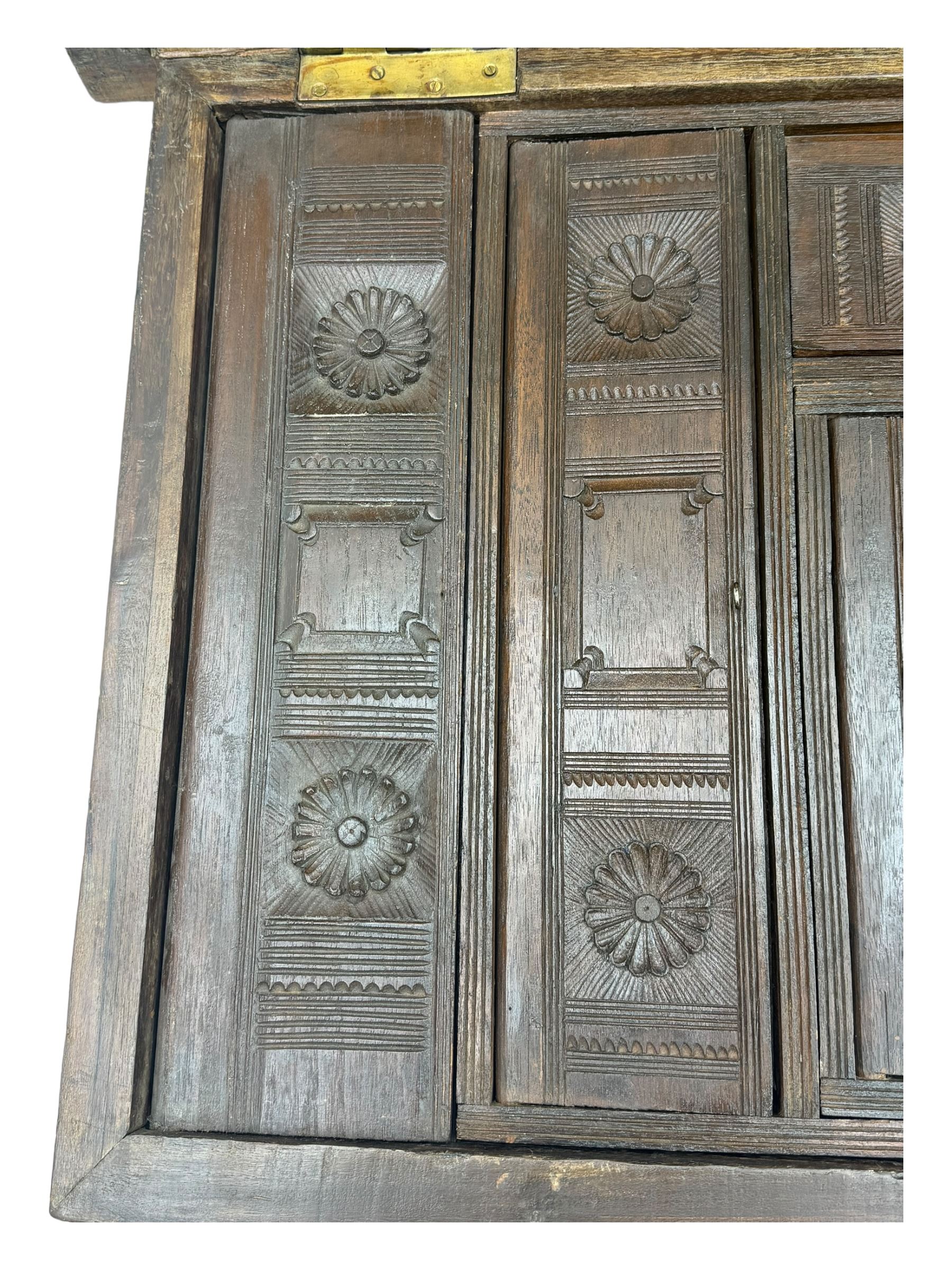 20th century mahogany chest, rectangular hinged top enclosing removable compartments with carved starburst motifs with linear and geometric patterns, brass inlay to the top and front, mounted corners and edges, on bracket base