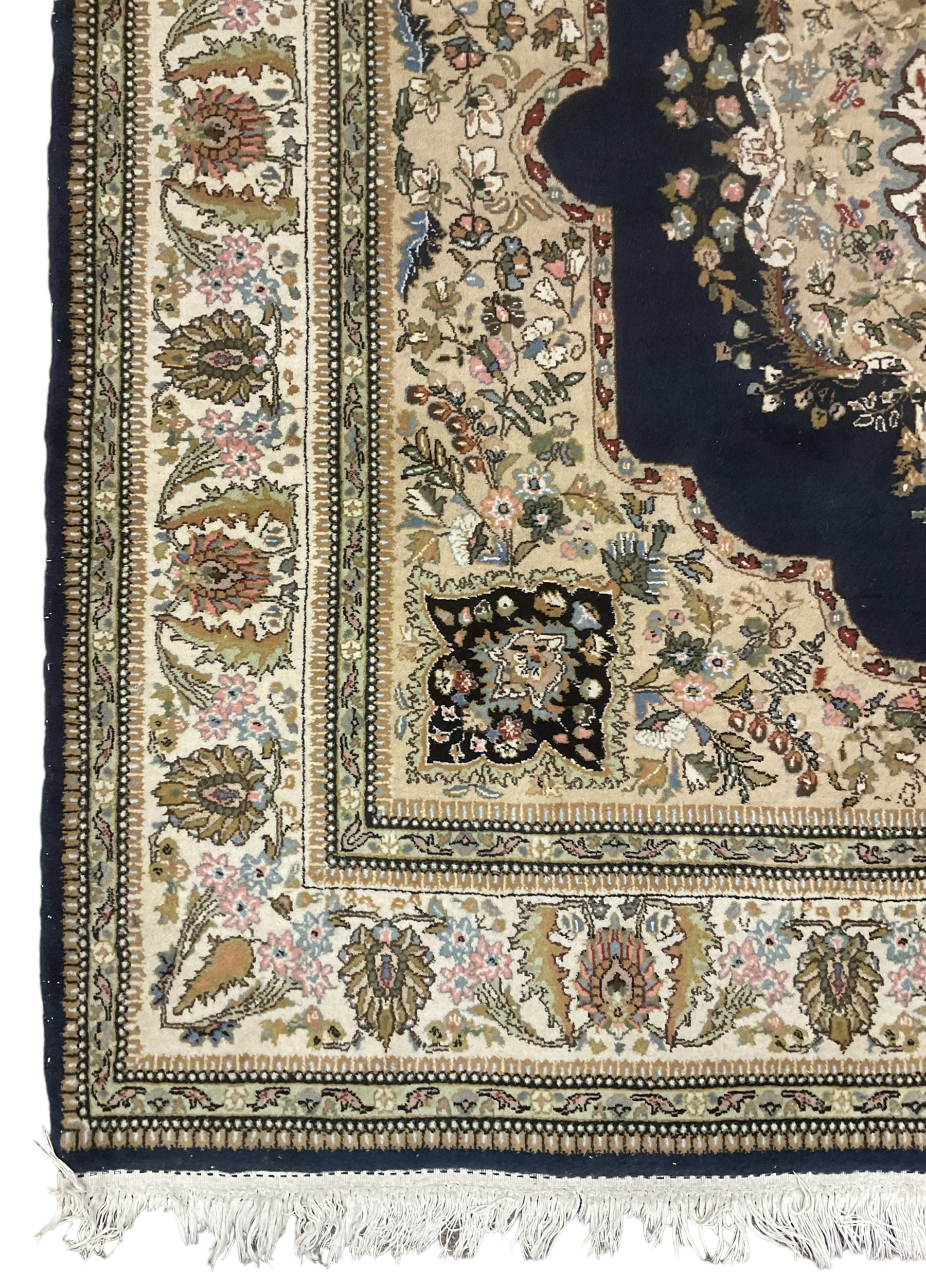 Persian Kirman indigo ground rug, central floral design medallion with matching spandrels, the guarded border decorated with stylised plant motifs 