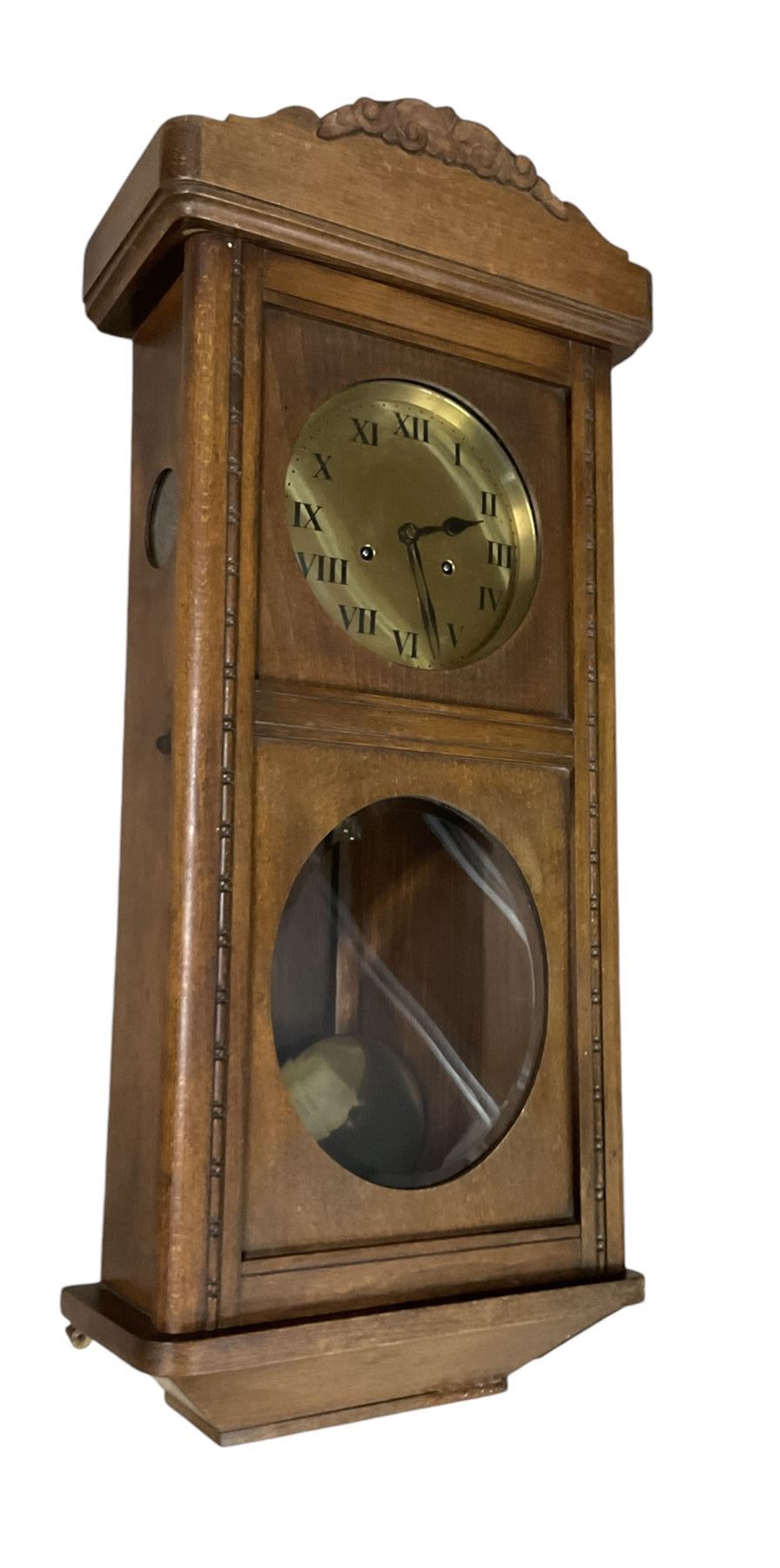 Two train oak cased wall clock, striking the hours on a coiled gong. With pendulum and key.