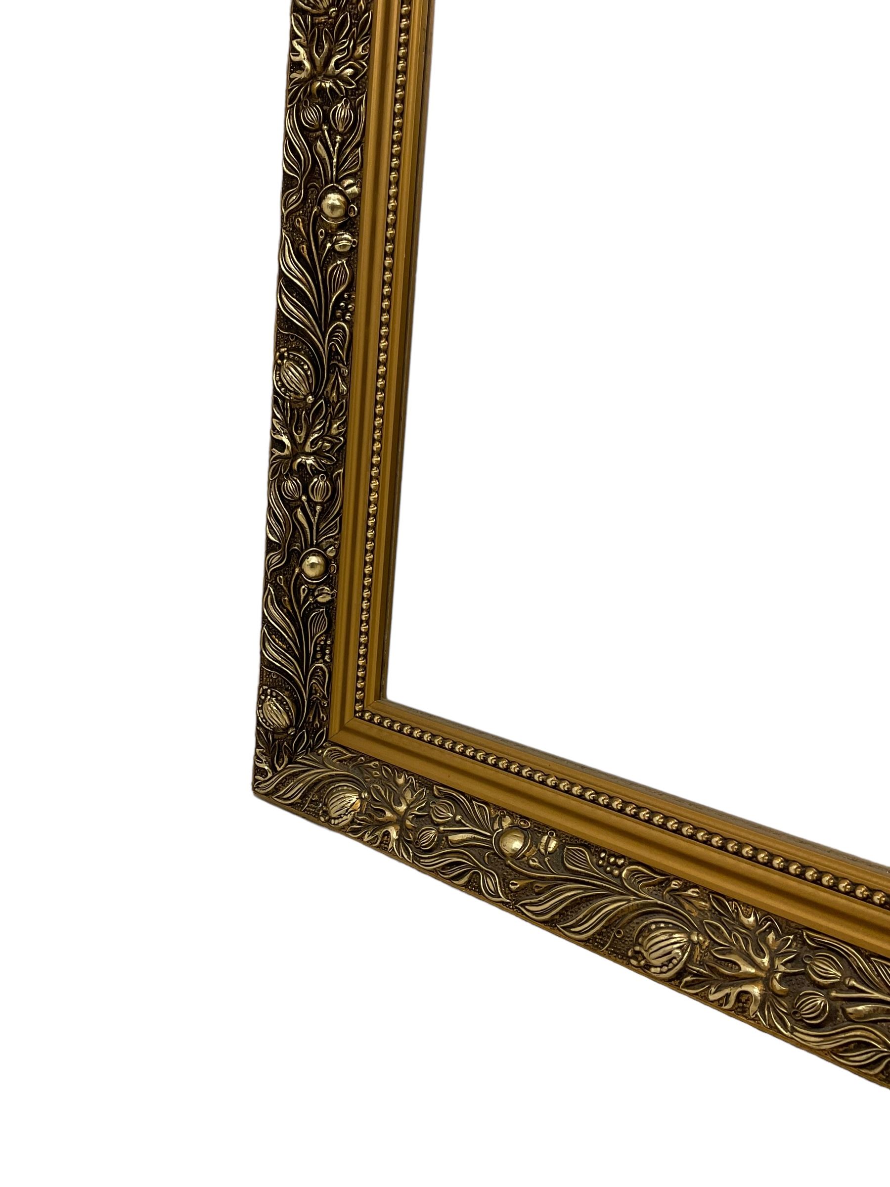 Large rectangular gilt framed wall mirror, decorated with trailing leafy branches and flowerheads, bevelled glass plate 