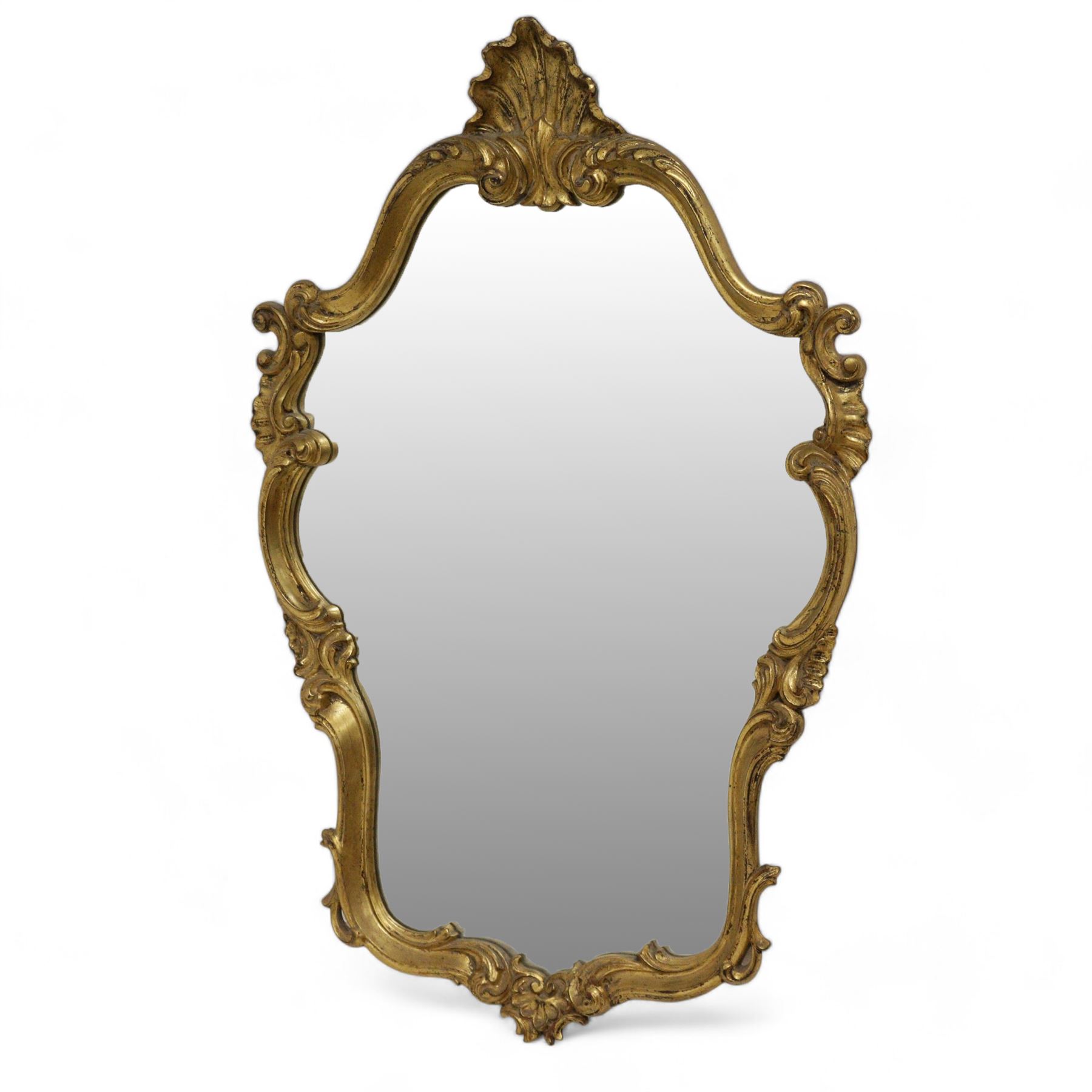 Ornate gilt framed wall mirror, shell pediment over scrolled foliate frame enclosing plain mirror plate