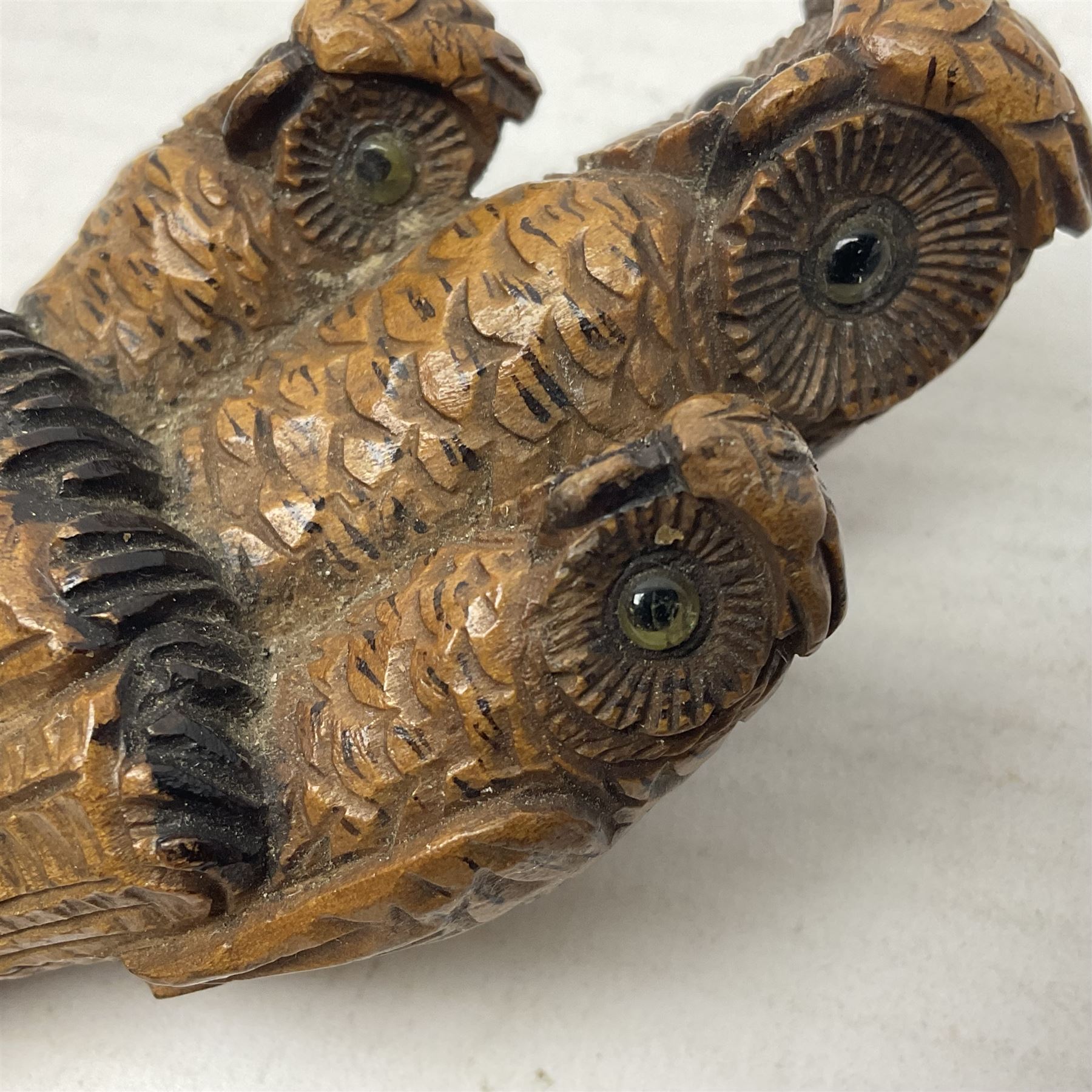 Late 19th/early 20th century Black Forest style carved walking stick handle, modelled as three owls with glass eyes, H9cm