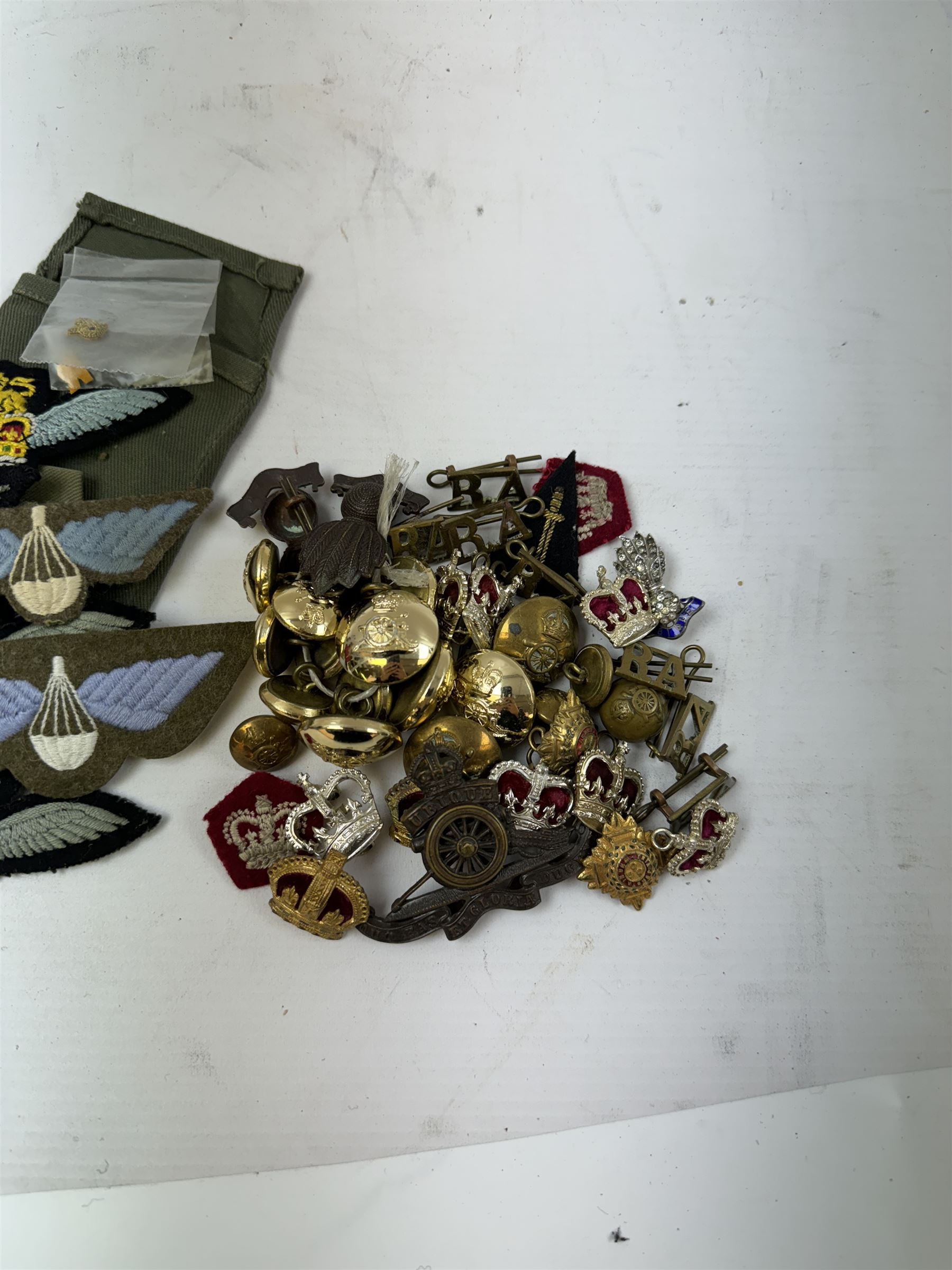 Various cloth and metal military badges including cap and collar badges, rank crowns and stars, staybrite button etc