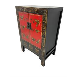 20th century Chinese black lacquered cabinet, rectangular body with two doors enclosing single shelf interior, adorned with gilt butterfly and floral motifs against a red backdrop, standing on square supports