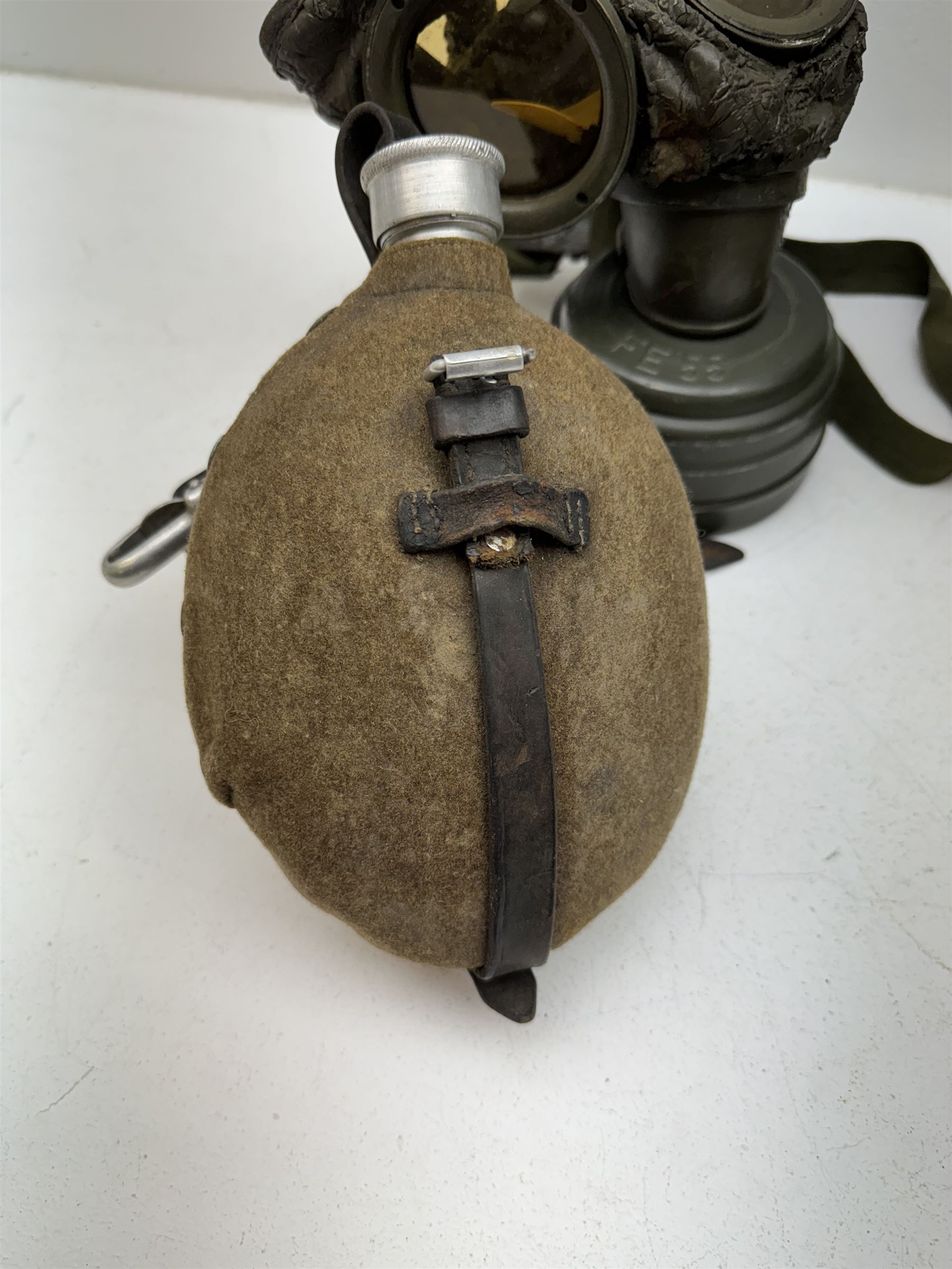 Two WWII German army canteen water bottles, together with German gas mask marked FE55 in a green fluted tin canister