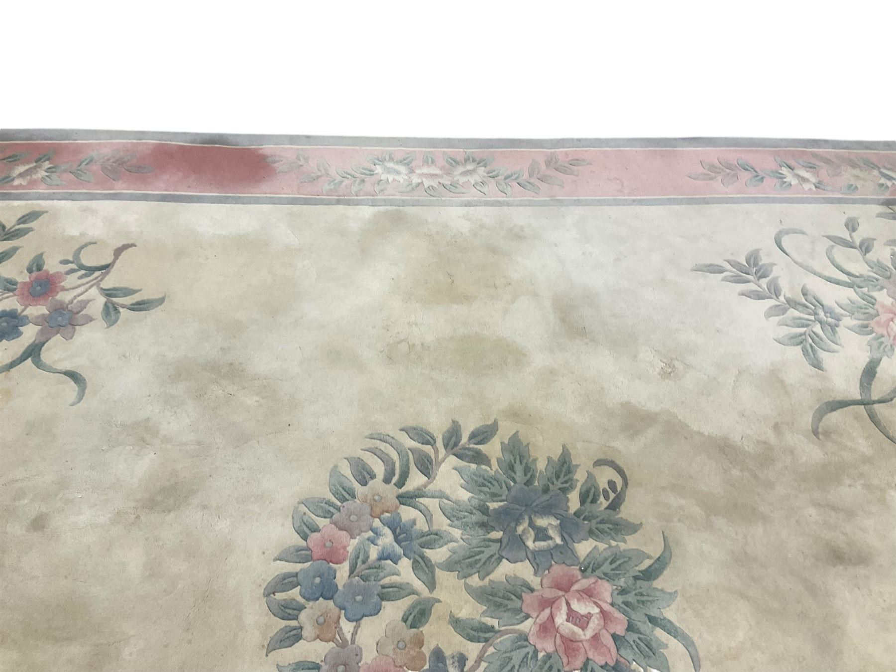 Chinese ivory ground washed woollen carpet, the field decorated with five large floral motifs with extending leafage, the wide rose guard band decorated with further floral patterns