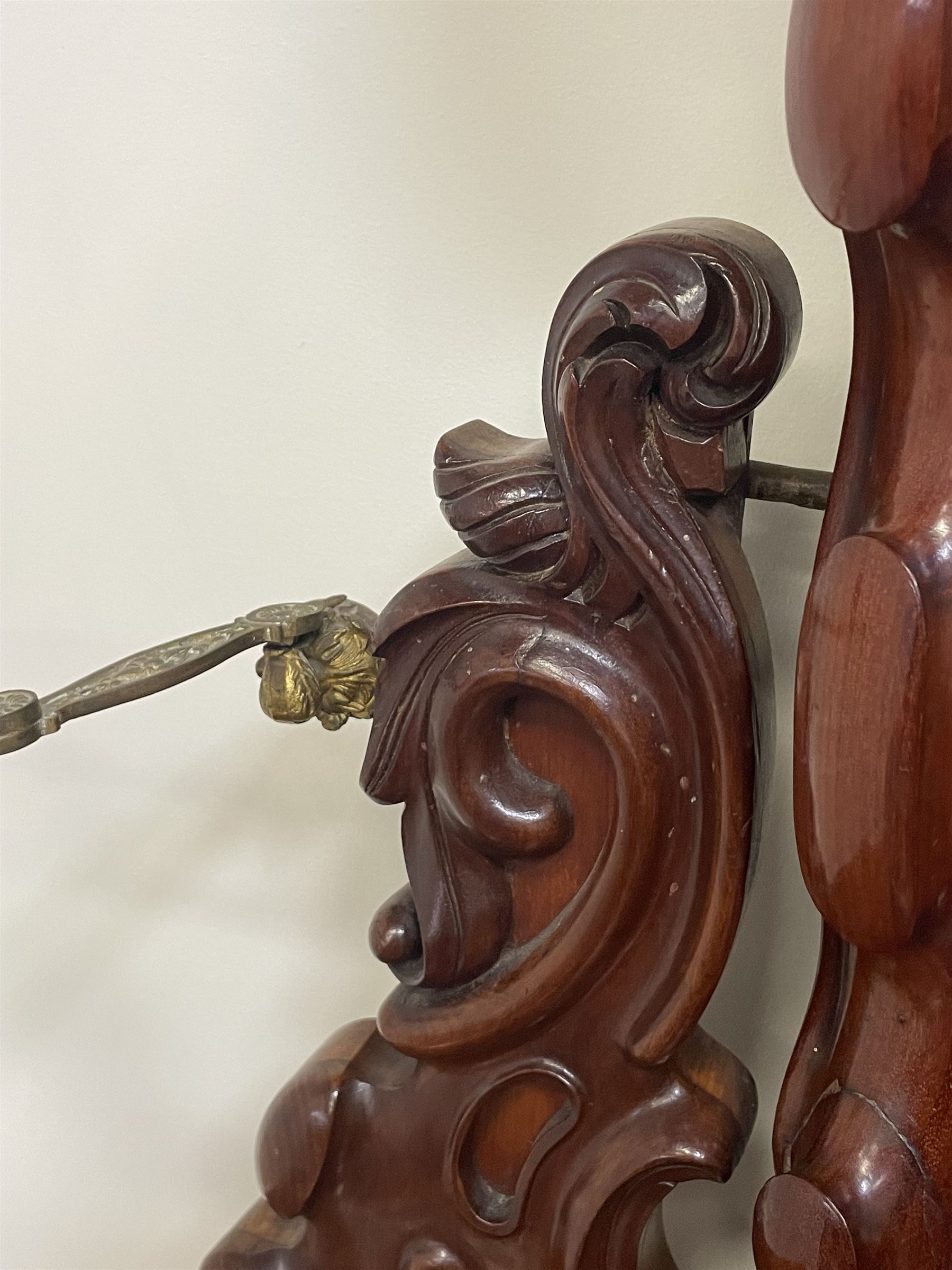 Tall Victorian figured mahogany twin pedestal dressing table, the tall mirror with flower head and scrolled leaf carved pediment, flanked by two turned and carved finials over faceted lancet arched lantern tops, plane mirror plate enclosed by shaped frame, pierced and undulating moulded uprights, on C-scroll and curled leaf carved supports fitted with cast brass hinged candle sconces, each pedestal fitted with two small trinket drawers over larger drawer and panelled cupboard, canted corners with matched upright mounts, the cupboard doors enclosing slides, on scroll carved feet 