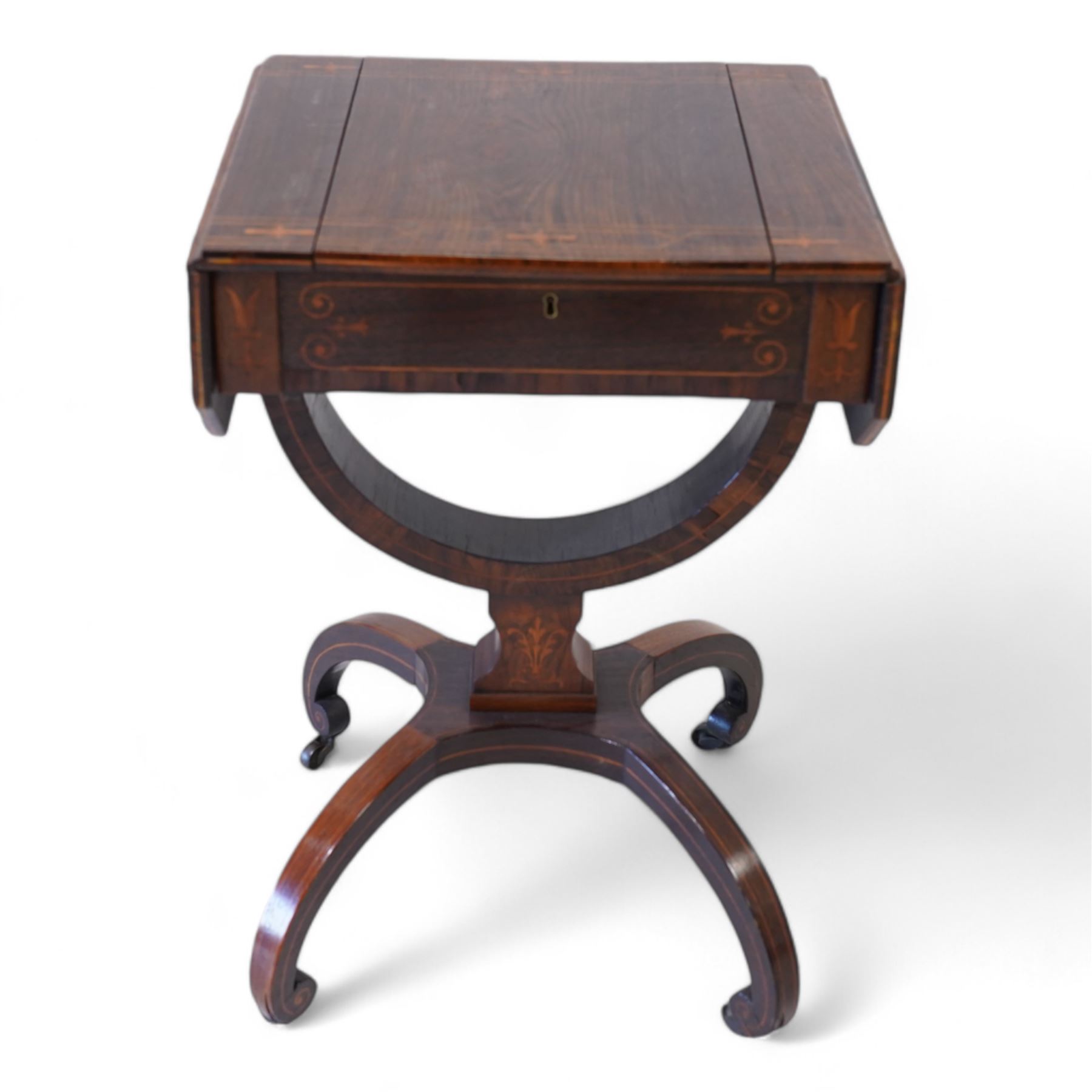 Victorian inlaid rosewood work or sewing table, the rectangular drop-leaf top with canted corners and inlaid with geometric banding, the hinged lid opening to reveal a central compartment surrounded by divisions, raised on a U-support terminating to arched supports with castors