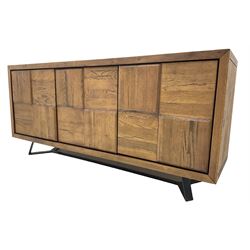 Samba 'Camden' oak sideboard, rectangular top over three block panelled cupboard doors, raised on angled black metal supports connected with stretcher