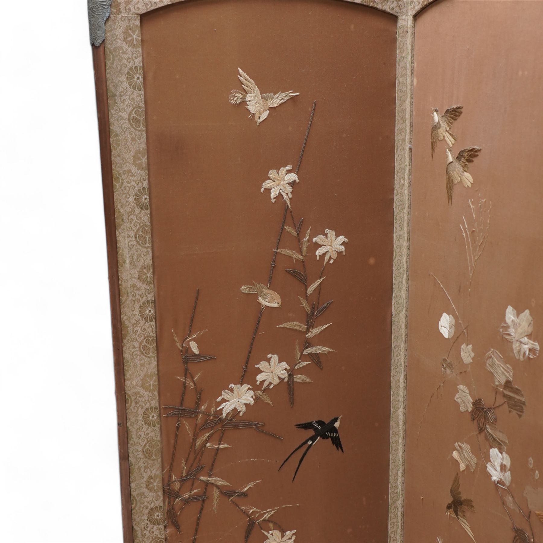 Early 20th century four panel dressing screen, each panel decorated with trailing foliage and birds in raised needlework 