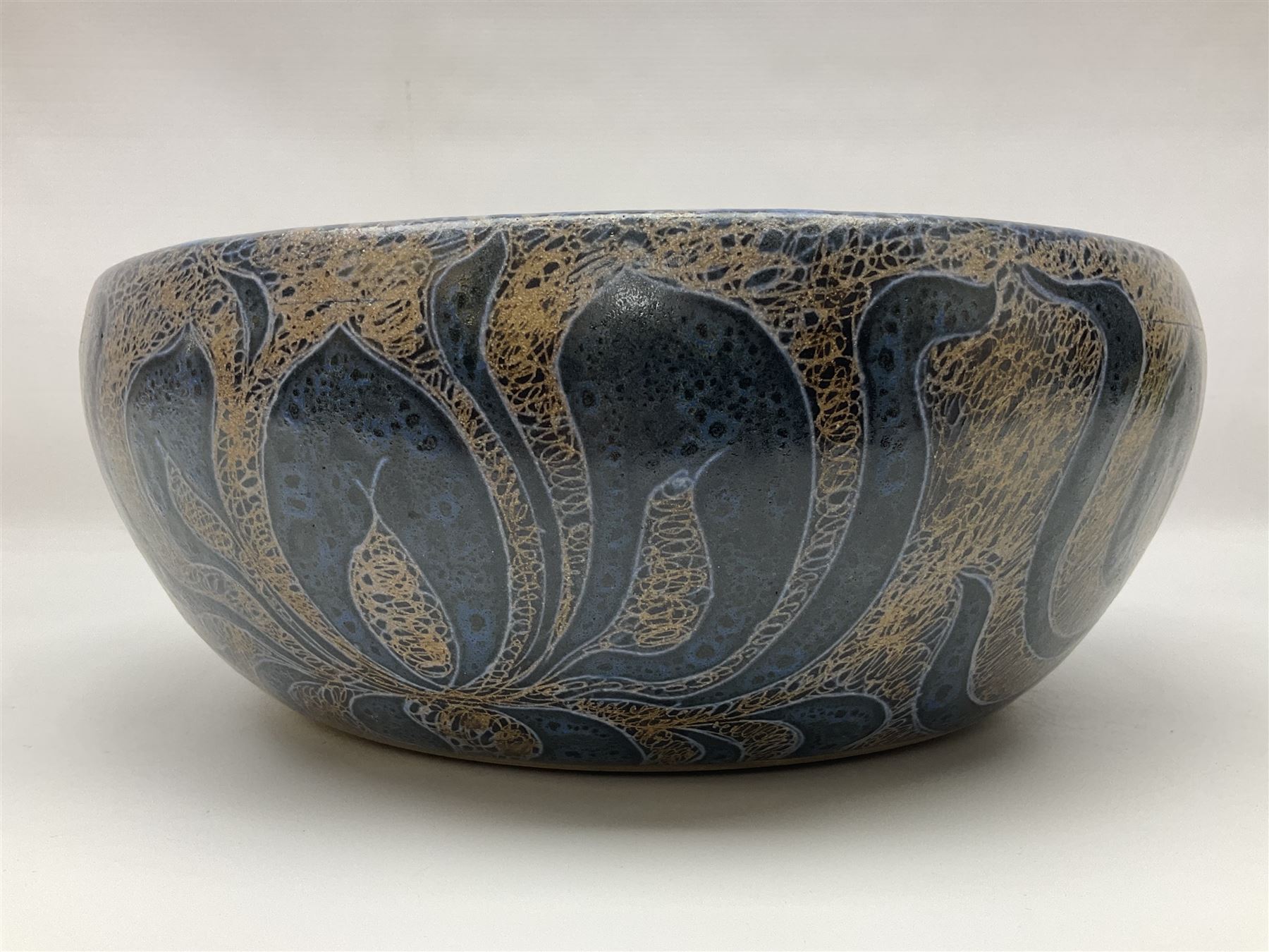 John Egerton (c1945-): studio pottery stoneware serving dish, decorated with abstract floral petals on a dark blue ground, D30cm