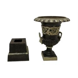 20th century cast iron Campana-shaped urn on plinth, with scrolling foliate relief decoration, in ebonised and silver painted finish