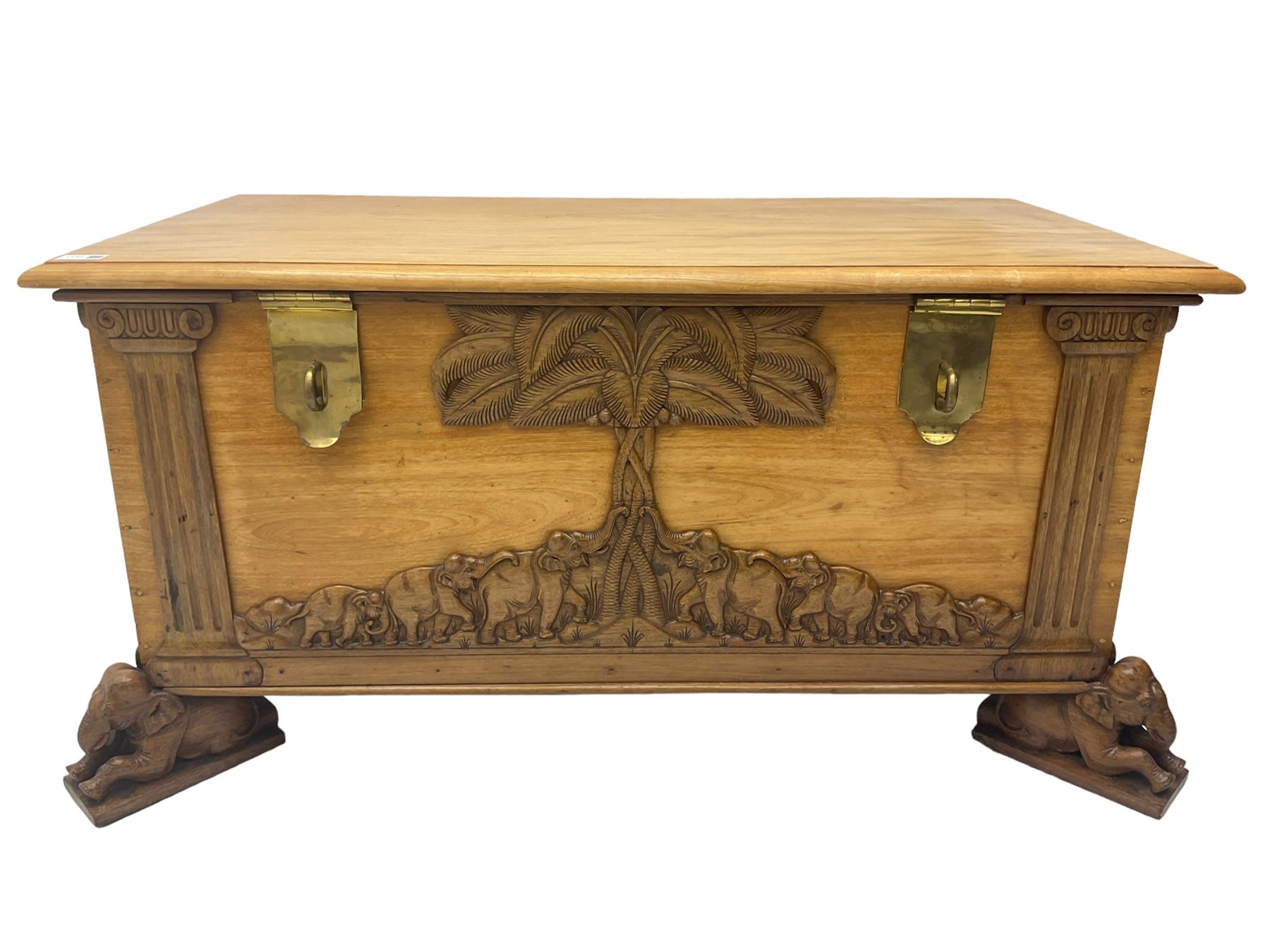 India camphor wood blanket box, moulded hinged lid, decorated with carved elephants and trees, on elephant carved feet