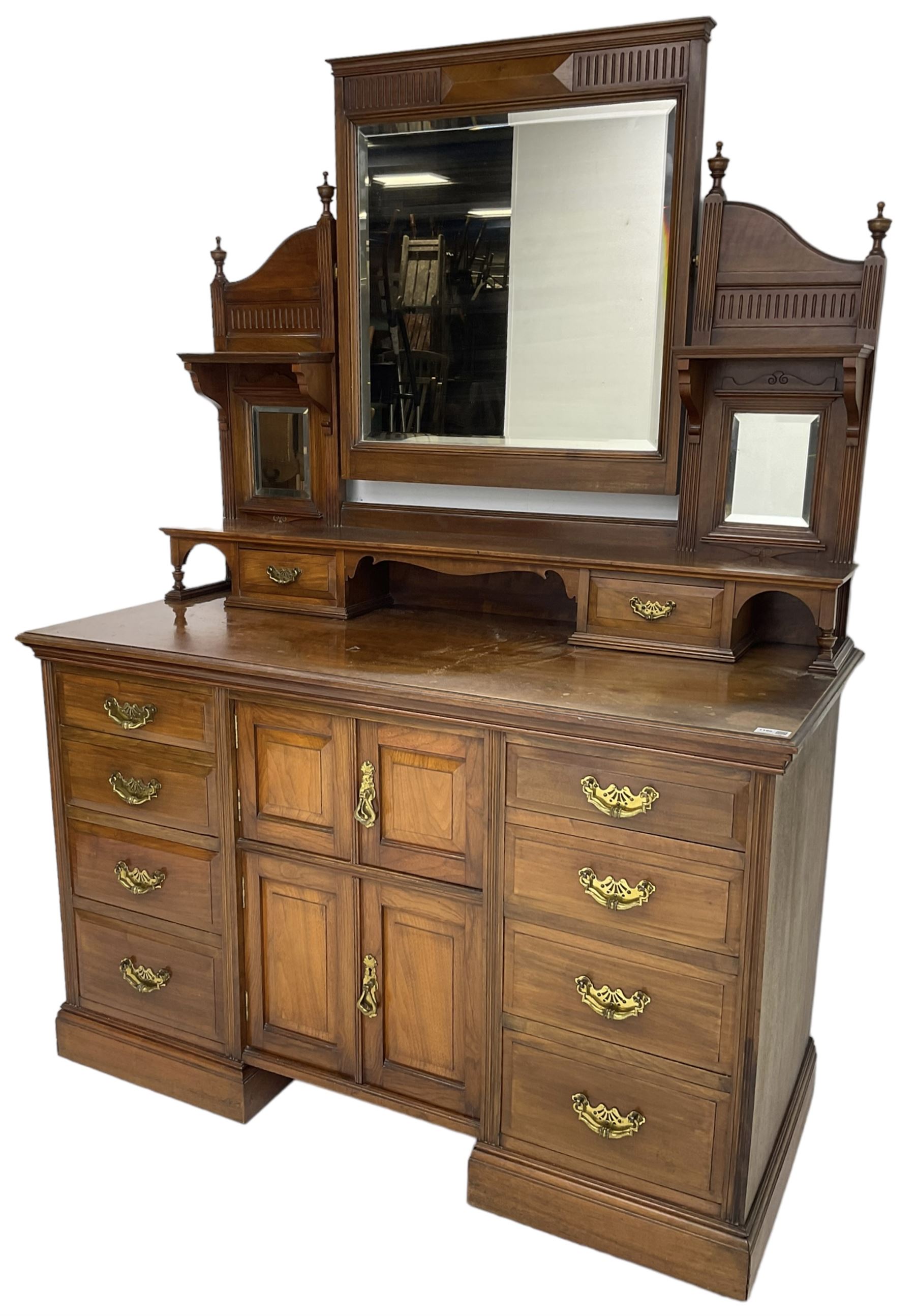 Edwardian mahogany dressing chest, raised triple mirror back with bevelled plates and fluted decoration over two trinket drawers, the base fitted with two central cupboards flanked by four graduating drawers to each side