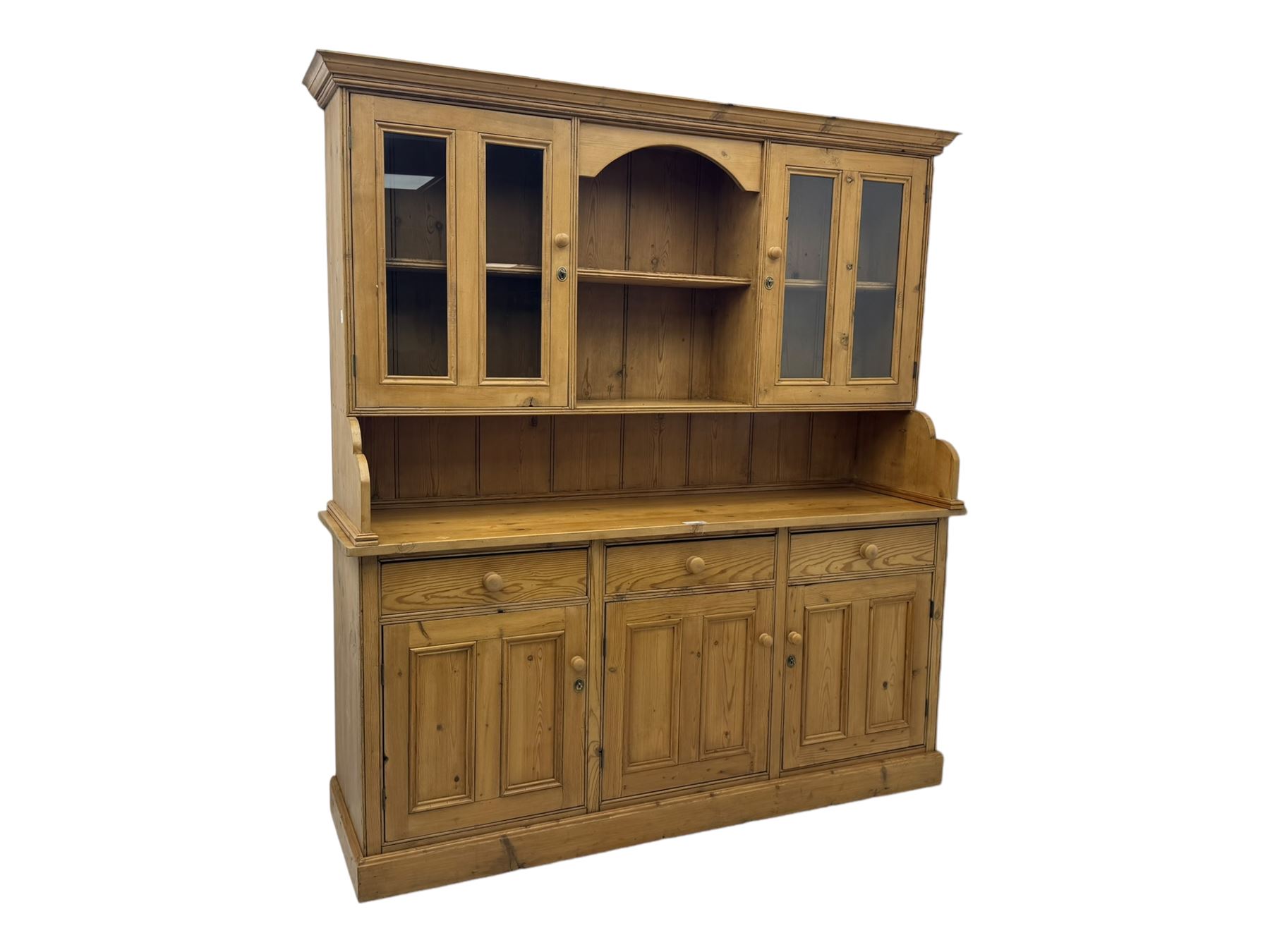 Large pine dresser, raised display cabinets over three drawers and three panelled cupboards, on plinth base